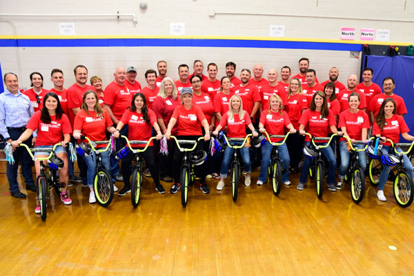 Volunteers pose with several bicycles that will be donated to deserving youth in the communities we serve.