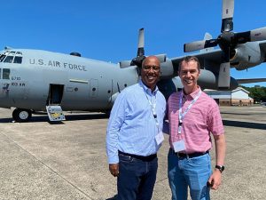 Ricky Jones and James Forshey stand in front of a Connecticut Air National Guard C-130.