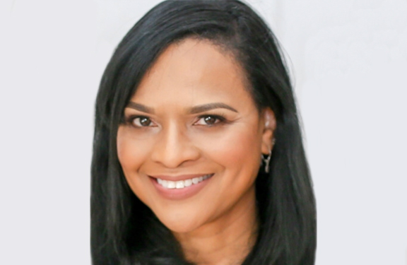 A female Travelers employee called Lynn smiles at the camera.