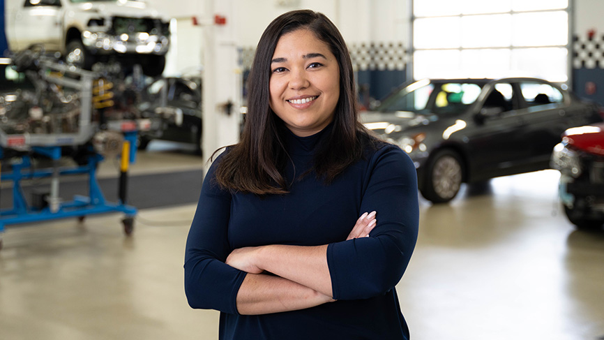 Woman smiling in an auto repair shop.