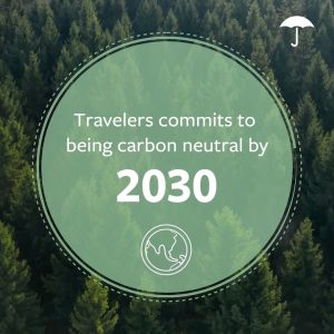 An aerial view of a lush evergreen forest with a semi-transparent green circular overlay in the center. Inside the circle, white text announces 'Travelers commits to being carbon neutral by 2030' with '2030' displayed in larger font. A simple line drawing of a globe appears below the text. The Travelers umbrella logo is visible in the upper right corner.